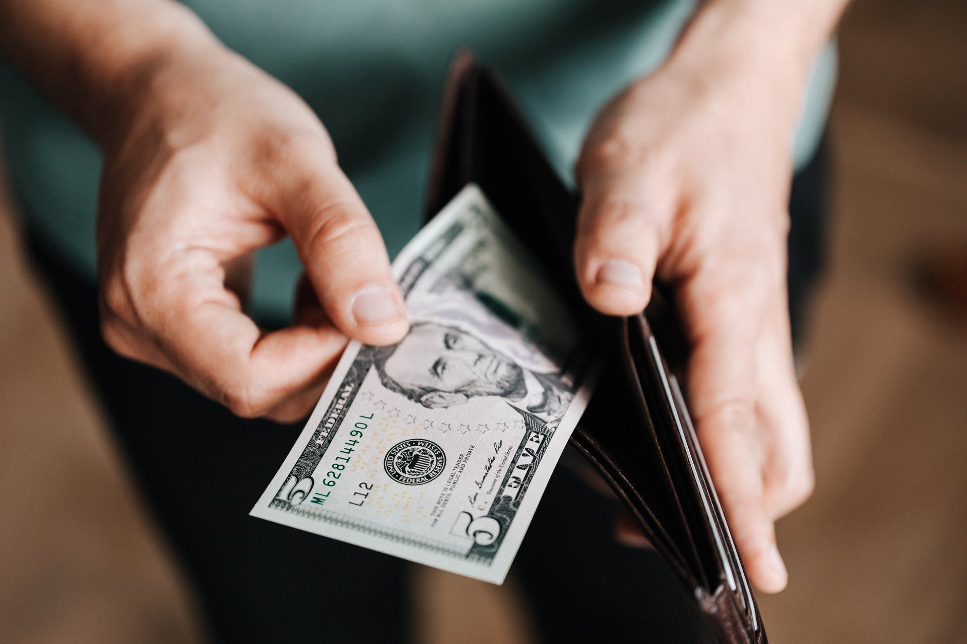 unrecognizable man holding wallet with money - Tips for Finding Perfect Babysitter