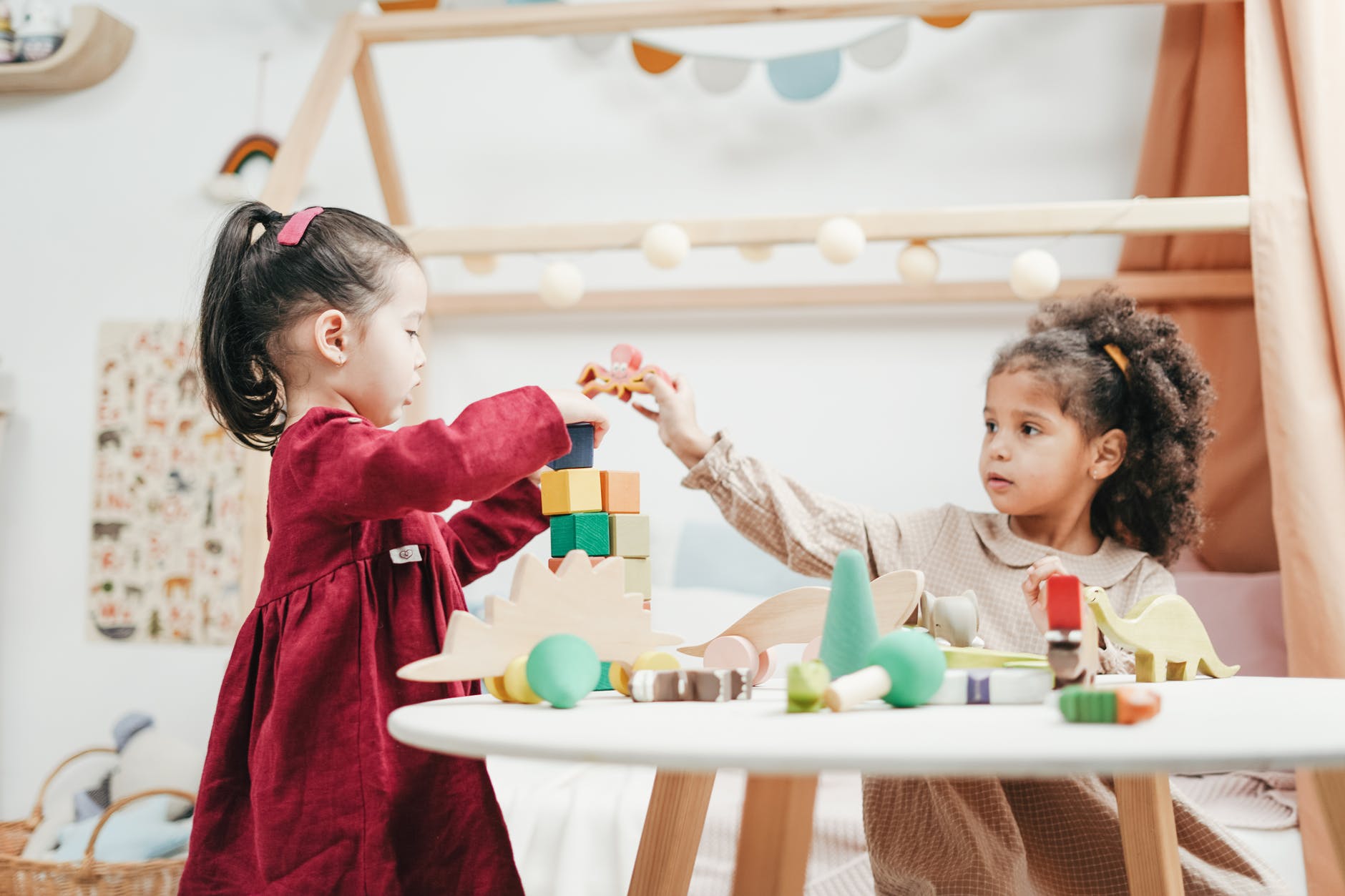 girl in red dress playing a wooden blocks