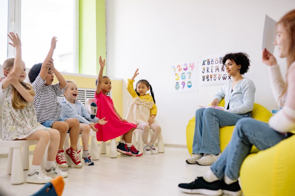 children raising their hands in a classroom