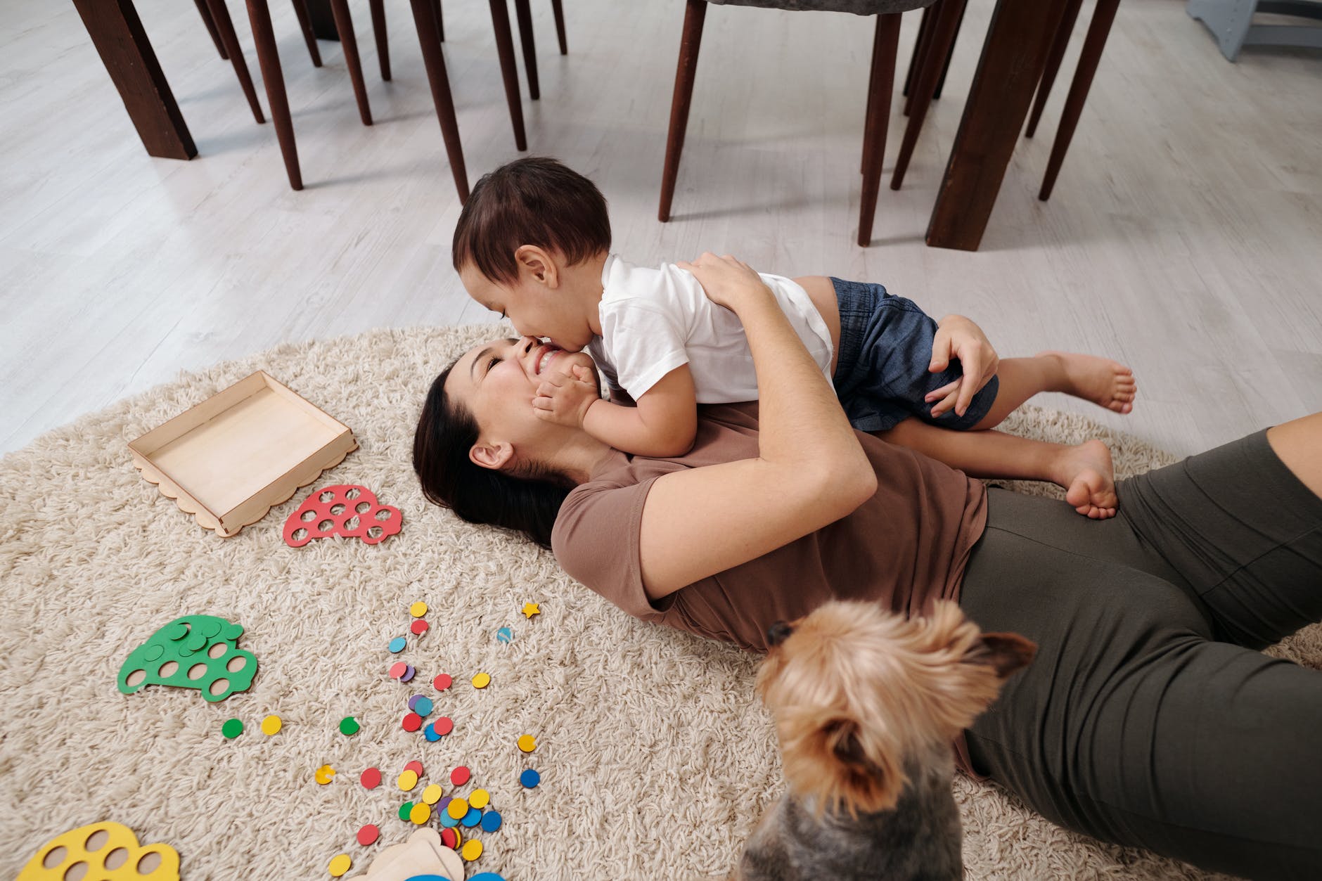 mother playing with child near the dog